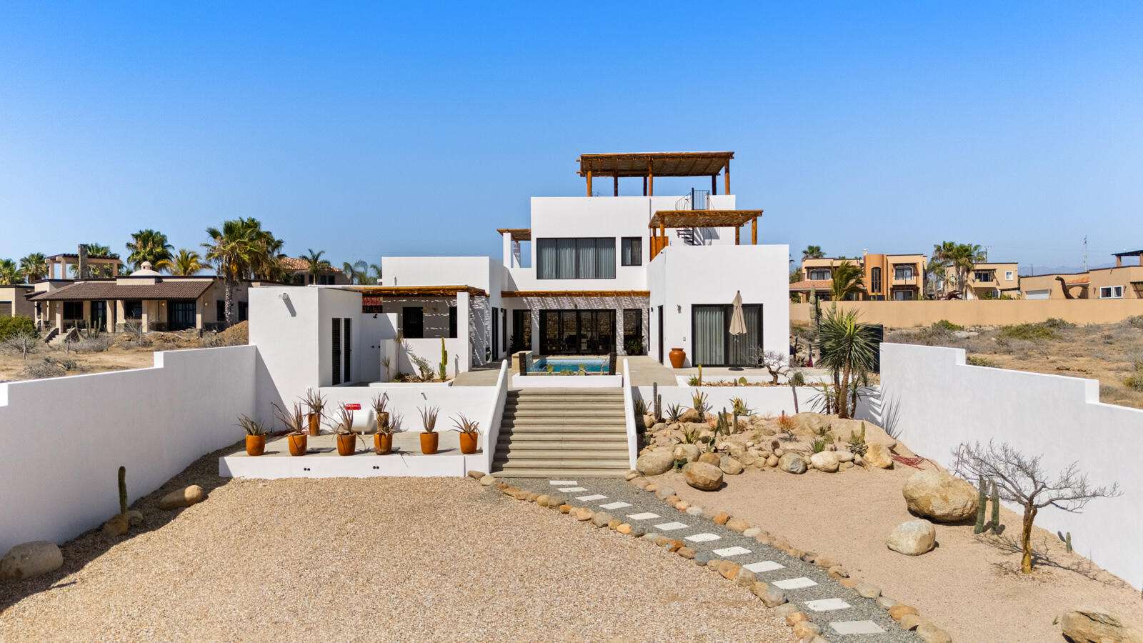 Todos Santos El Posito We are excited to introduce Casa Elisabeth, an amazing, newly constructed custom home in the private El Posito area of Todos Santos. Located just three rows back from the beach, this three-bedroom, three-full and two-half bathroom residence offers every amenity desired for a tropical paradise. The downstairs features an open-concept living room, dining room, and a fully stocked kitchen with brand-new appliances, including a dishwasher. The main floor also includes a laundry room and an outdoor water feature with a professionally designed rock wall. The principal bedroom downstairs offers a unique indoor/outdoor bathroom with two showers and an outdoor bathtub.Each of the three bedrooms includes an en-suite bathroom with double vanities. The upstairs bedroom features its own private furnished terrace and access to one of four large patios, complete with a bar area and outdoor furniture perfect for enjoying ocean sunsets. Additionally, a shaded third-floor observation deck provides panoramic ocean and mountain for sale