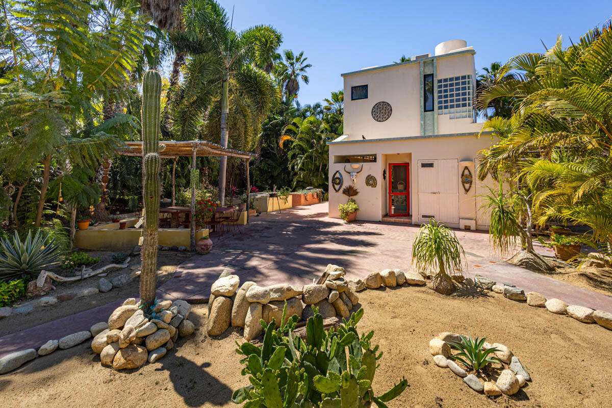 Todos Santos La Cachora Charming Tropical Beachside Retreat in Todos Santos. Nestled in the sought-after La Cachora seaside community of Todos Santos, this enchanting property is located at the end of a serene cul-de-sac on Brock Lane, named after the builder of the charming homes in the neighborhood. This residence beautifully combines traditional Mexican architectural elements with a modern twist, highlighted by a remodeled kitchen that caters to contemporary tastes.The main house features 1 bedroom and 1.5 baths, designed for comfort and functionality. Surrounded by inviting palapa shade porches, the exterior space offers an ideal setting for relaxation and entertaining, seamlessly blending indoor and outdoor living. A quaint palapa serves as a multifunctional art studio, adding a creative workshop space to the property. The second structure a more contemporary studio casita. Complete with a full bath, kitchenette, and a rooftop hammock deck overlooking the lush surroundings, this studio is perfect for guests or as a rental opportunity. The deck also features a palapa, and a swimming pool, providing a delightful space for leisure. Profoundly landscaped gsardens are a true highlight, featuring a rich array of fruit trees, cacti, agaves, pomegranates, and aloe, along with mature exotic palms. Park-like Setting**: Meandering footpaths connect the main house to the garden and the studio casita, creating a magical, private oasis that feels like a tranquil retreat. The home is within a short, leisurely walk to La Cachora beach, ensuring easy access to the mighty Pacific and local attractions. This tropical paradise offers peace of mind in a stunning environment, ideal for those seeking a blend of artistic inspiration and serene living. Whether utilized as a primary residence, guest accommodations, or rental income, this property exemplifies the charm and allure of Todos Santos living. for sale